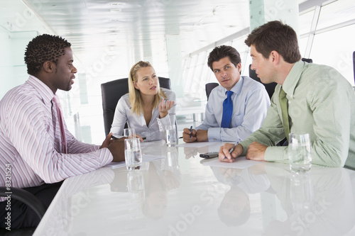 Four businesspeople in a boardroom talking photo