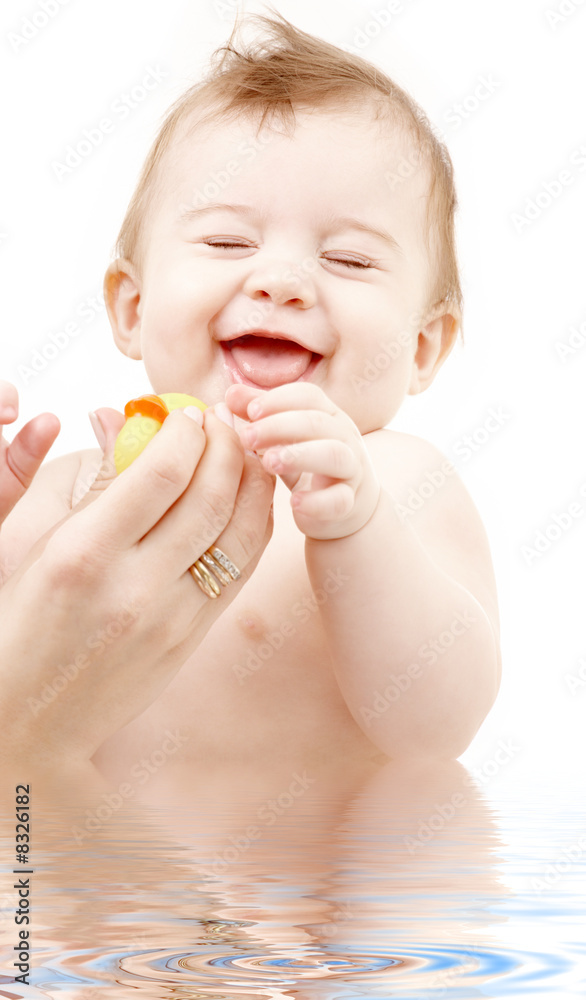 laughing baby boy in water playing with rubber duck laughing baby boy in water playing with rubber duck