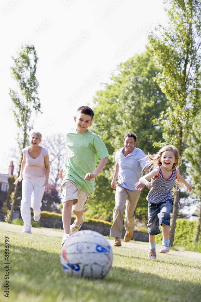 Obraz premium Family outdoors playing soccer and having fun