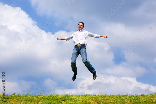 Happy man is jumping on a field