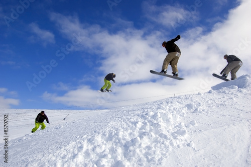 Snowboarders jumping