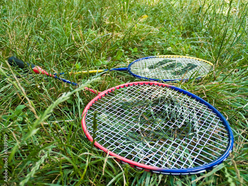 Two badminton rackets in grass