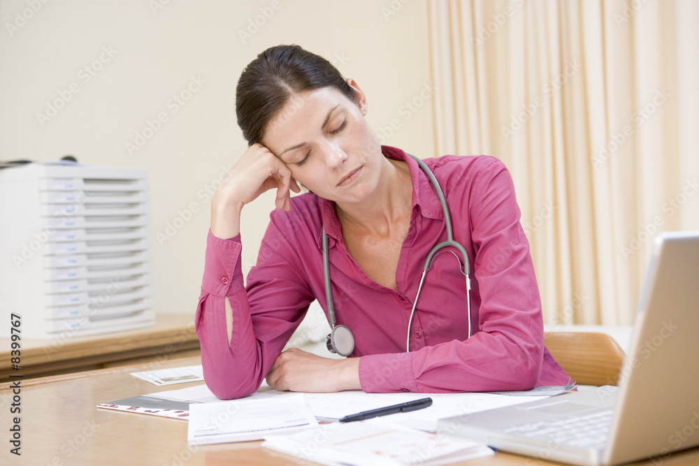 Doctor with laptop sleeping in doctor's office Doctor with laptop sleeping in doctor's office