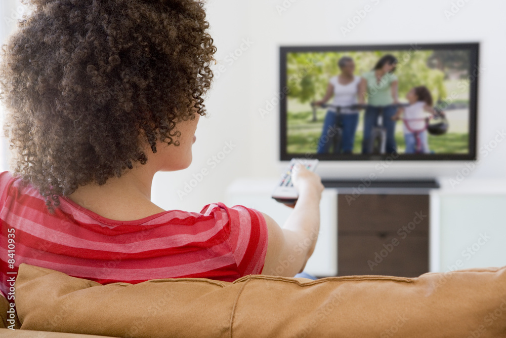 Woman in living room watching television Woman in living room watching television