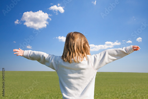 Girl with Arms Stretched in Green Field