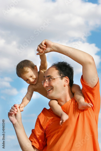 father playing with son over sky background