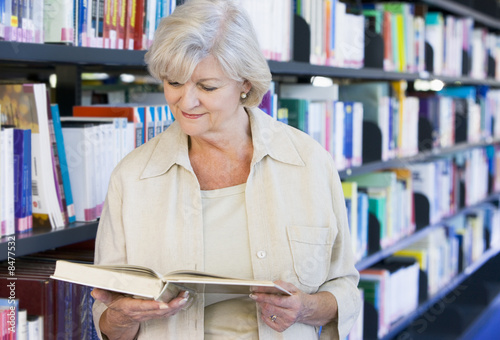 Senior woman reading in a library