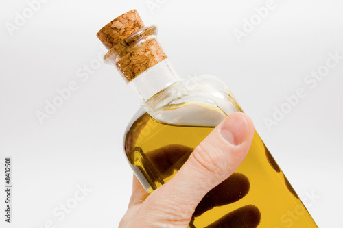 man keeps a bottle of olive oil. closed-up