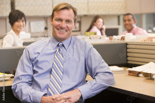 Fényképezés Businessman in cubicle smiling