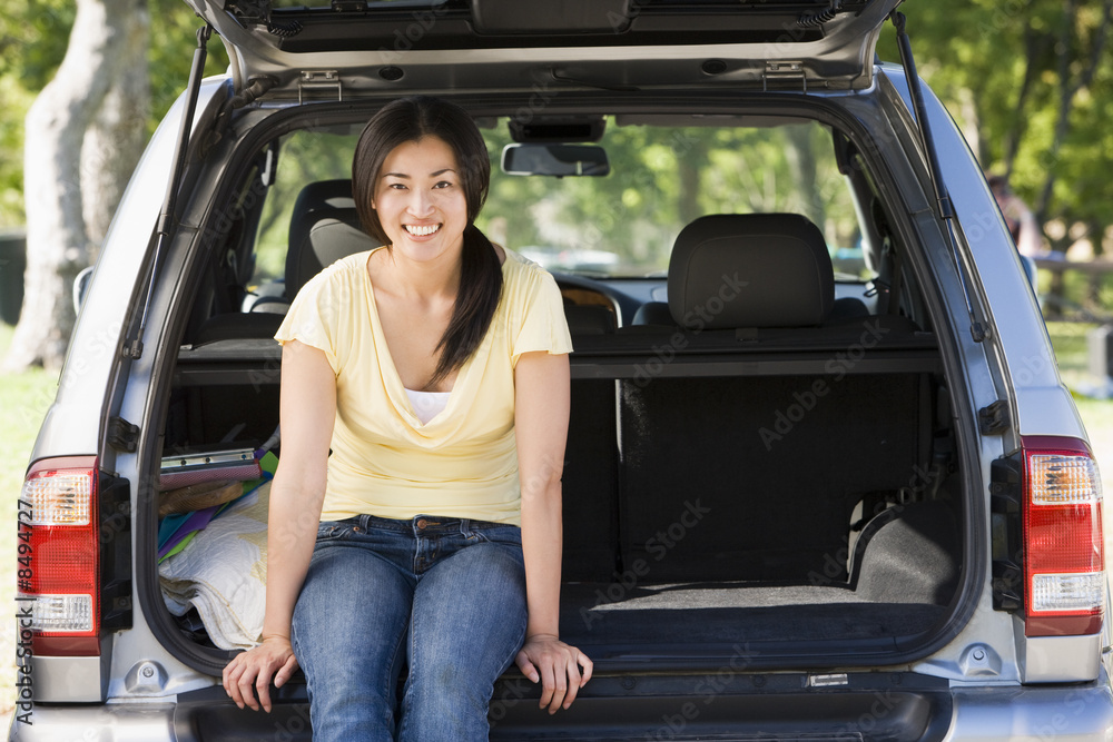 Woman sitting in back of van smiling