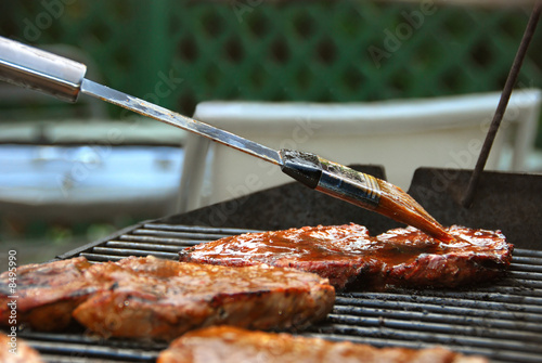 Applying BBQ Sauce to Steak on a Grill