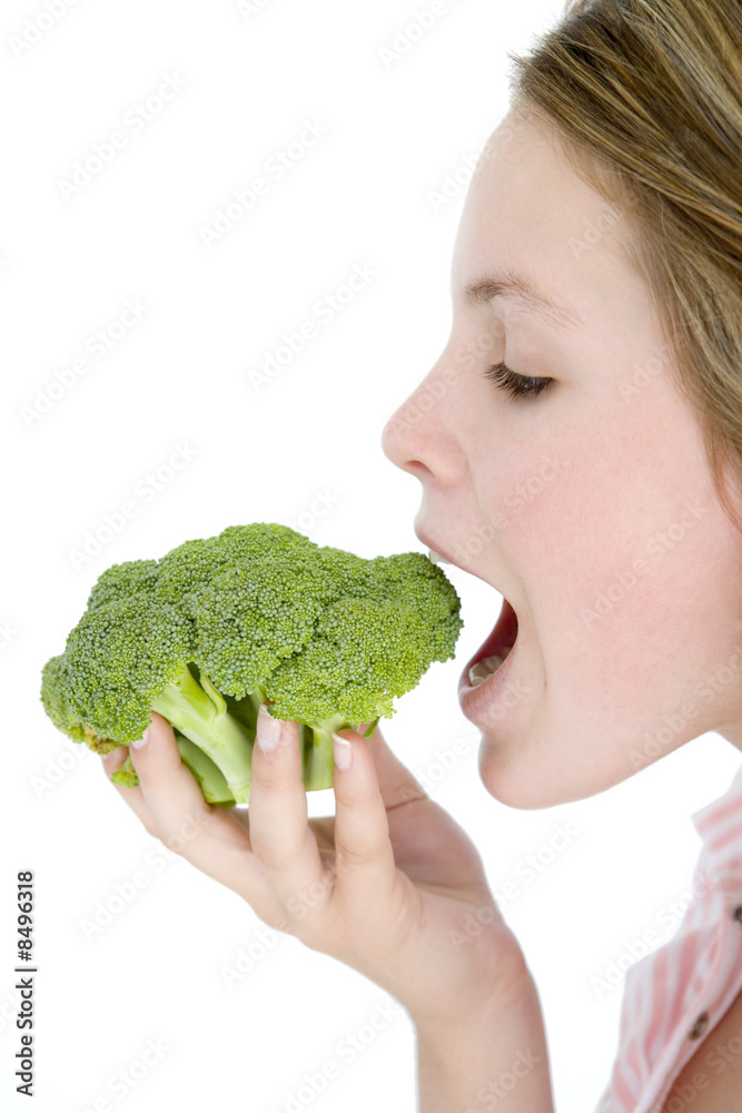 Teenage girl eating broccoli Teenage girl eating broccoli