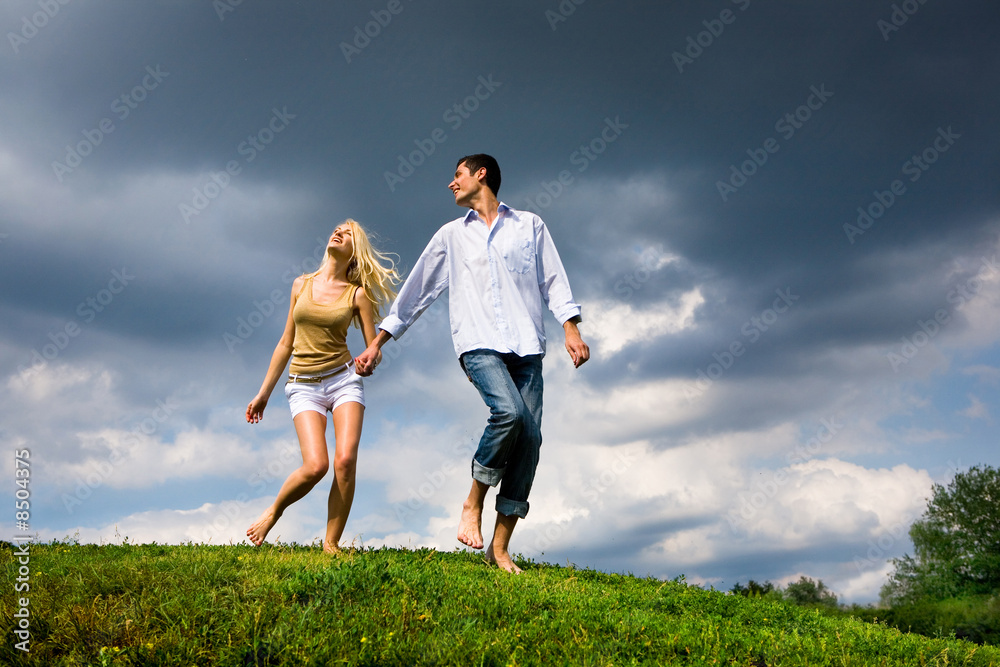 Young couple walking through summer lawn Young couple walking through summer lawn