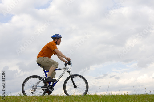 Mountainbiker fährt auf einer Wiese