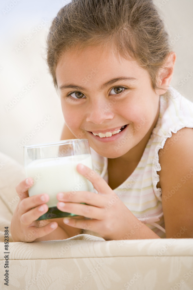 Young girl drinking milk in living room smiling Young girl drinking milk in living room smiling