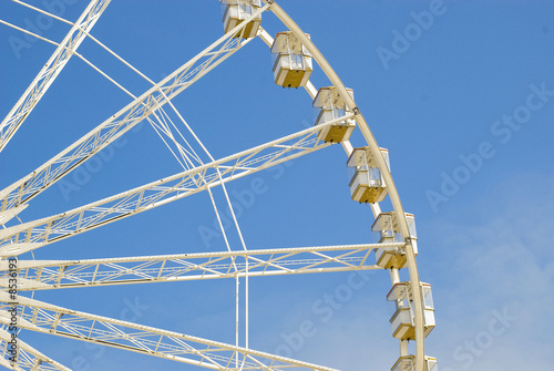 Fragment of a big wheel against the blue sky