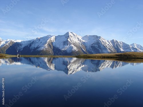 Reflection in the water of the quiet Bettmersee Lake in Valais photo