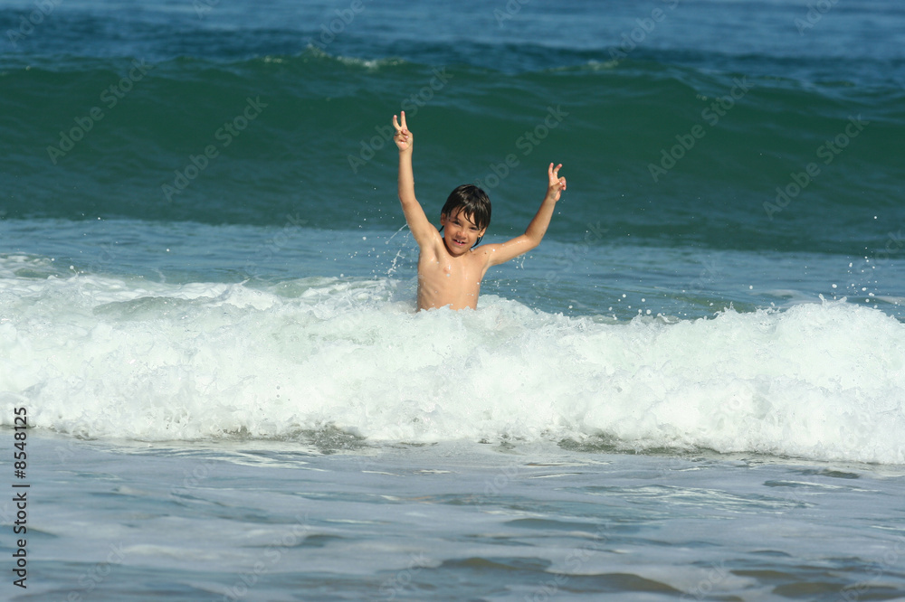 petit garçon entrain de jouer dans les vagues petit garçon entrain de jouer dans les vagues