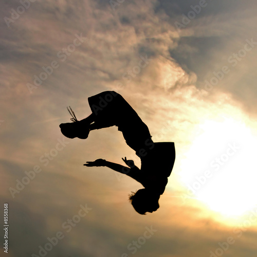 silhouette of jumping man against sky and clouds © artjazz