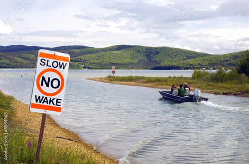 A boat defies the No Wake sign at a lake