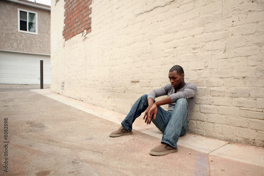 Depressed Young African American Man Leaning Against Alley Wall Depressed Young African American Man Leaning Against Alley Wall