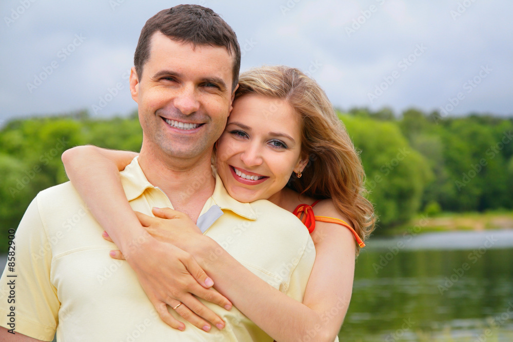 young woman embraces man from back young woman embraces man from back