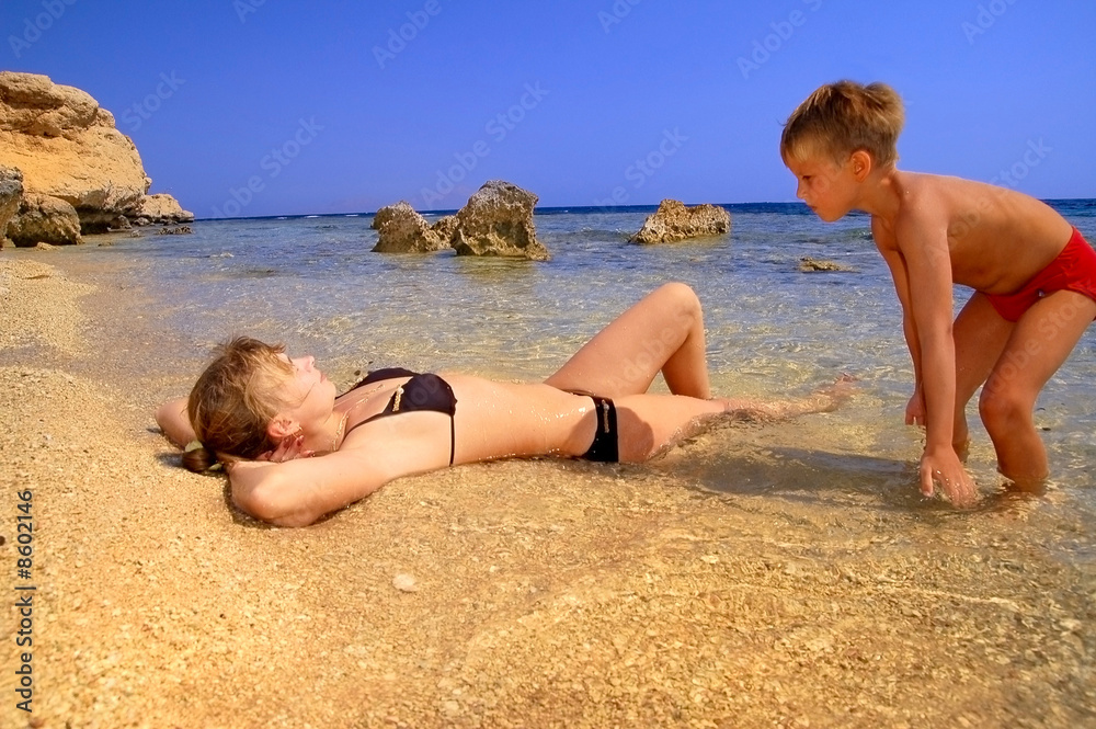 ma and son on beach on background blue sky ma and son on beach on background blue sky