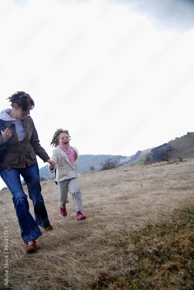 happy mother and daughter running in nature