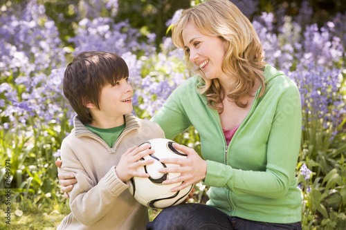 Mother and son outdoors holding ball smiling © Monkey Business