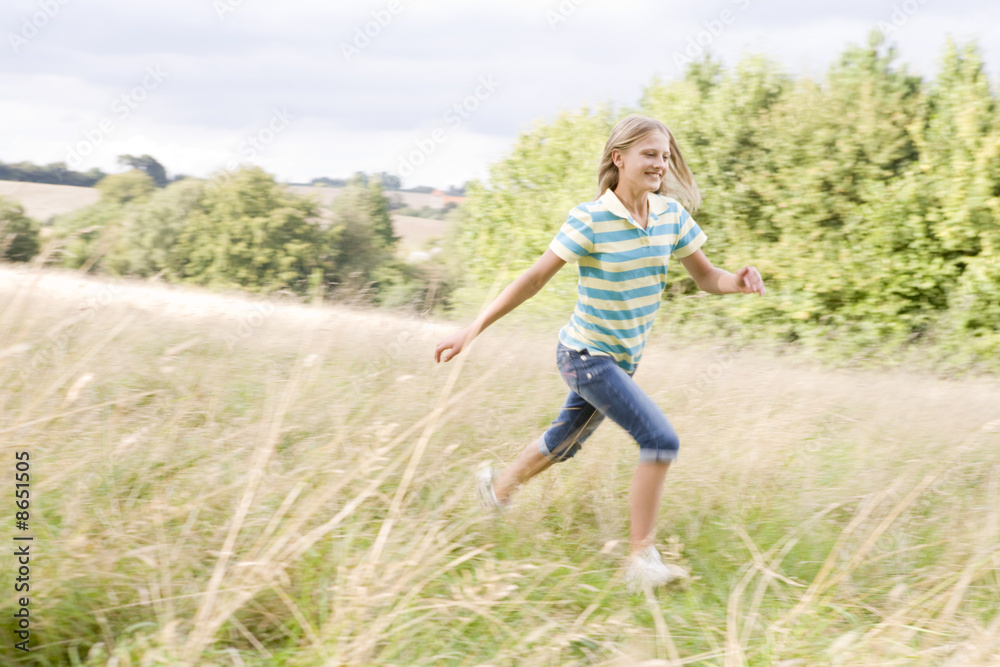 Young girl running in a field smiling Young girl running in a field smiling