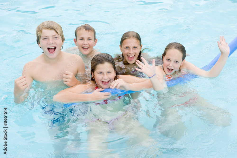 Five young friends in swimming pool playing and smiling Five young friends in swimming pool playing and smiling