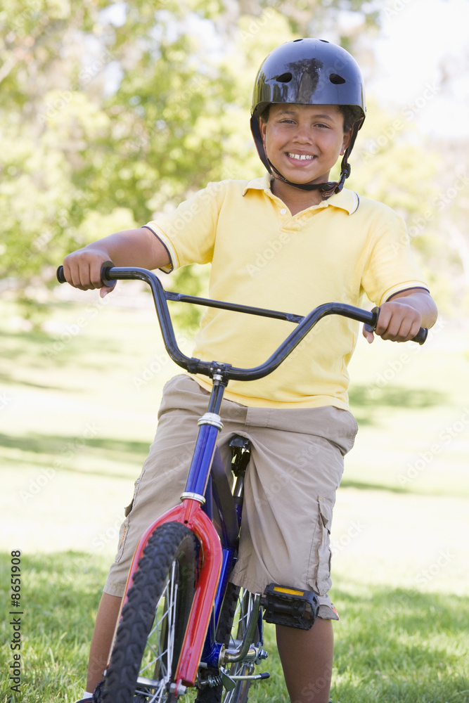 Naklejka premium Young boy on bicycle outdoors smiling