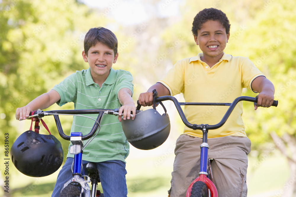 Obraz premium Two young boys on bicycles outdoors smiling