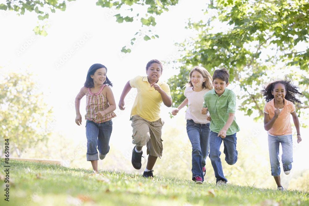 Five young friends running outdoors smiling