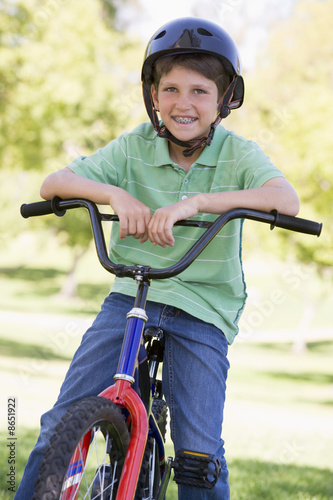 Young boy on bicycle outdoors smiling
