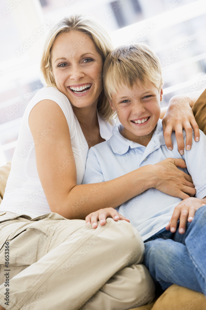 Woman and young boy sitting in living room smiling Woman and young boy sitting in living room smiling