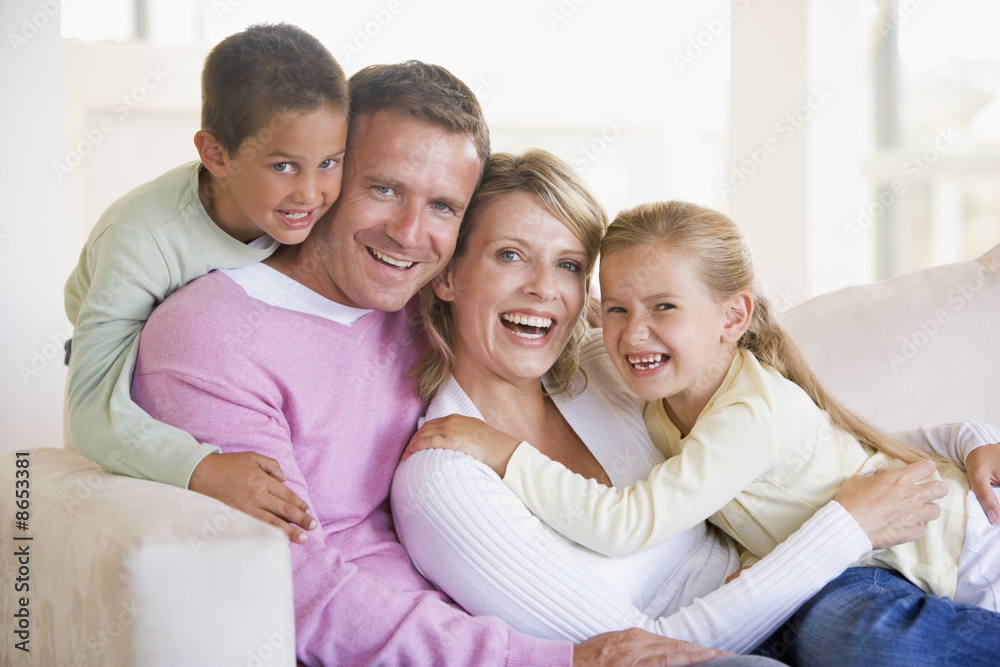 Family sitting in living room smiling