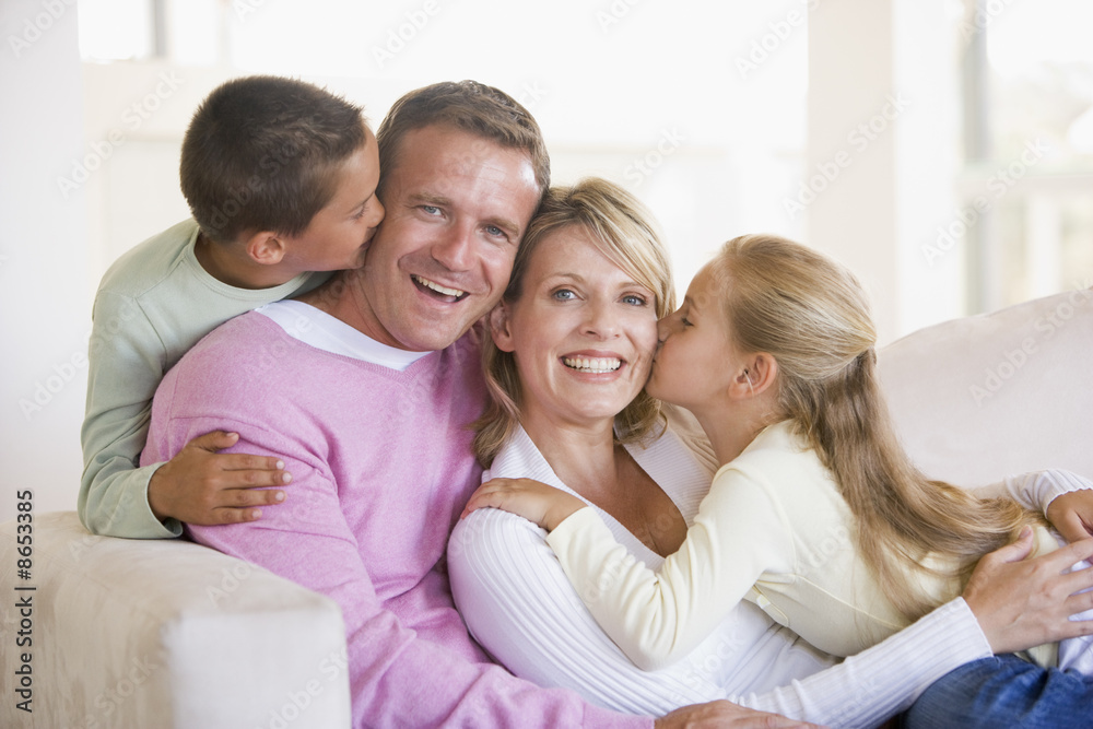 Family sitting in living room kissing and smiling