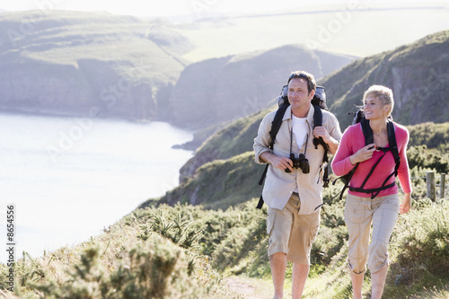 Couple on cliffside outdoors walking and smiling