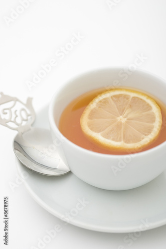 Tea serving in white cup with spoon and lemon slice