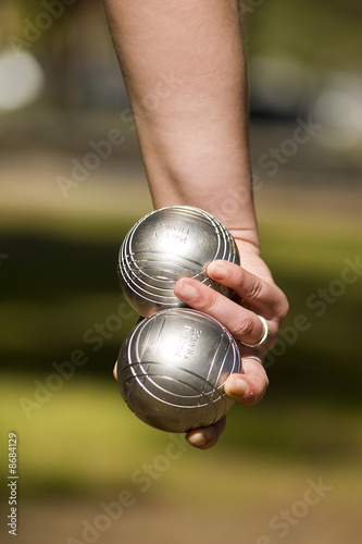 main tenant deux boules de pétanque