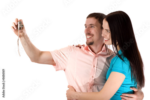 Young couple taking a photo of themselves (isolated on white)
