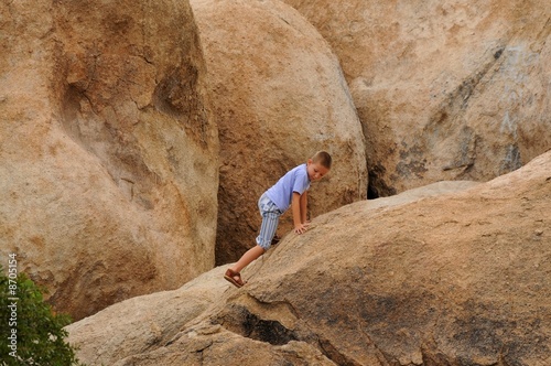 Boy Climbing On Rocks