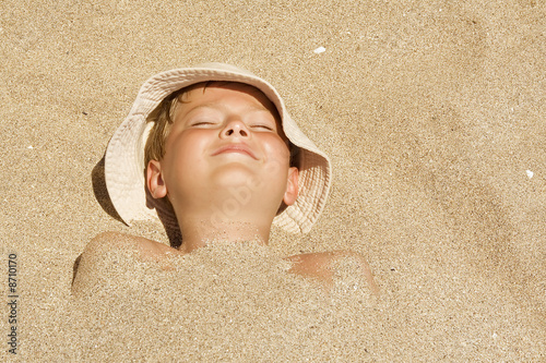 Tableau sur toile Child buried in the sand