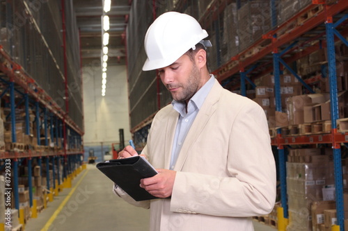 worker making notes at the warehouse