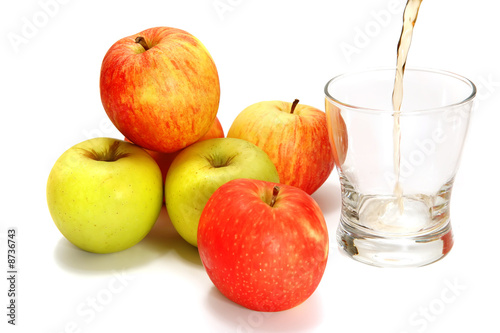 apples over white with filled glass