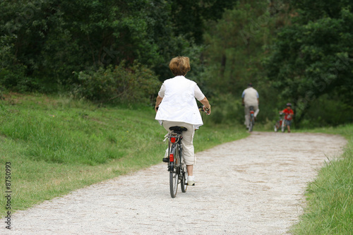 femme à la retraite entrain de faire du vélo en forêt