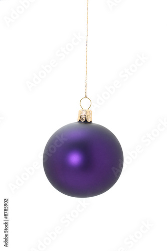 A violet christmas ball hanging from golden thread