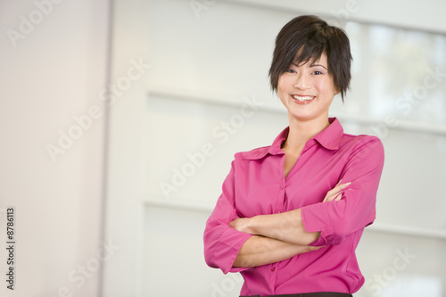 Businesswoman standing indoors smiling Free Download Businesswoman standing indoors smiling - GFXLoad