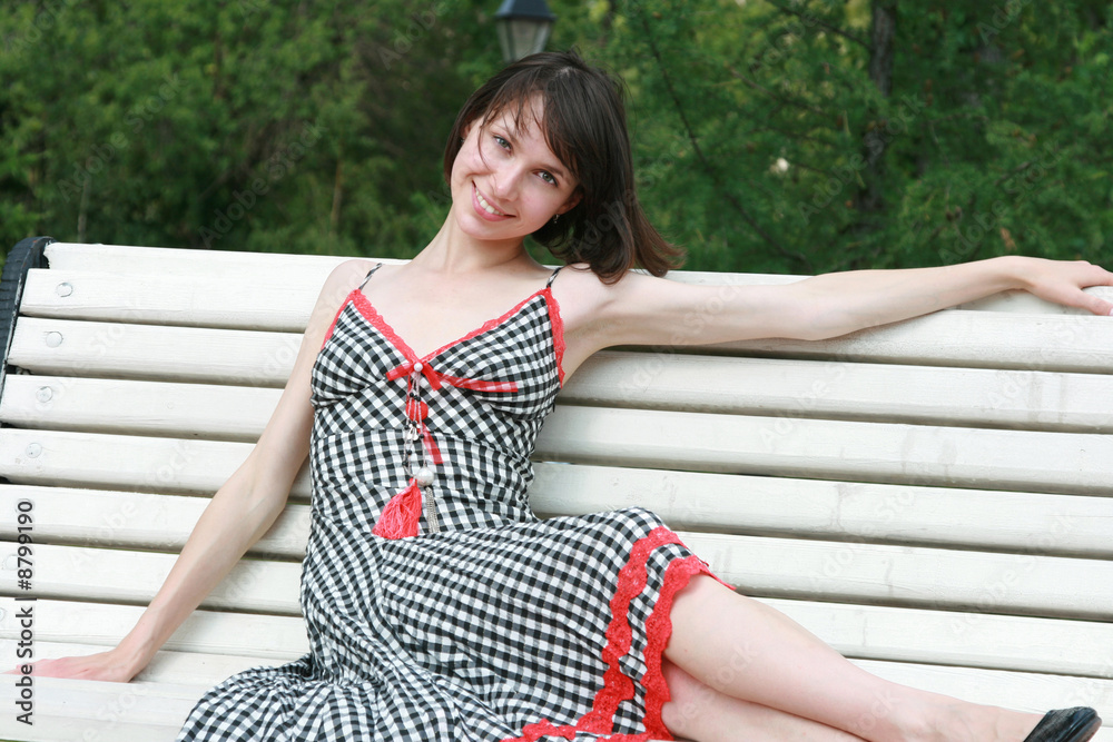 The beautiful girl poses on a bench The beautiful girl poses on a bench